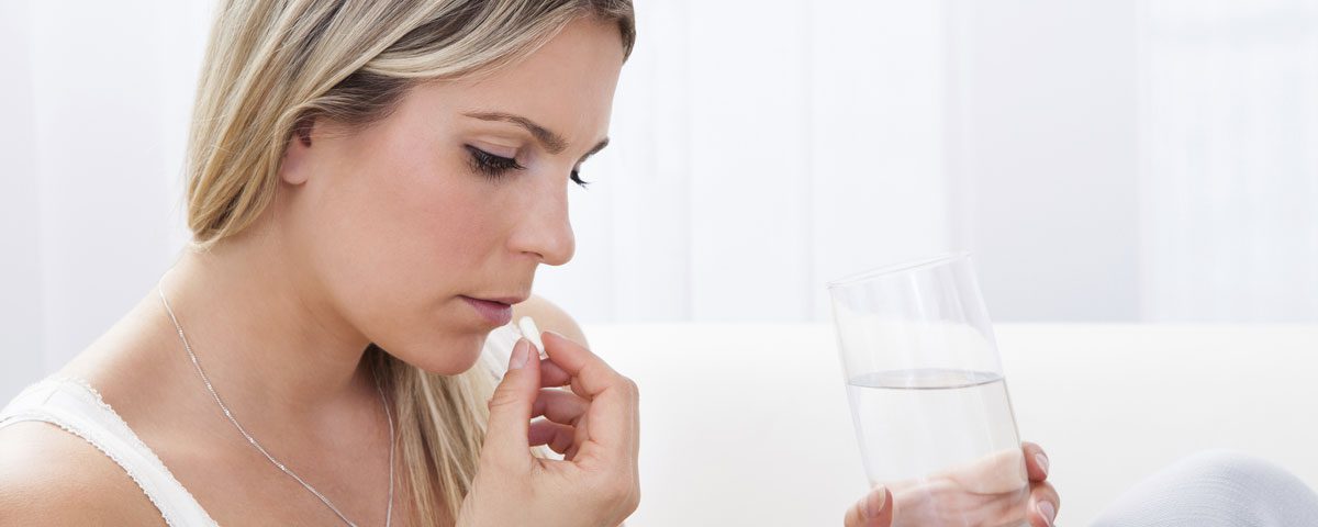 woman drinking pill